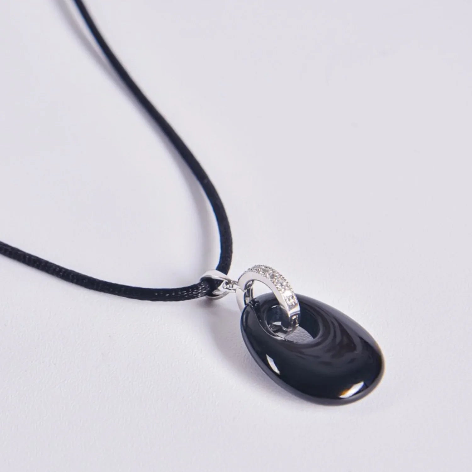 Colgante de piedra ónix negro ovalada con asa de plata rodiada y circonitas, incluye cordón negro, propiedades hipoalergénicas, selección Aura Plena