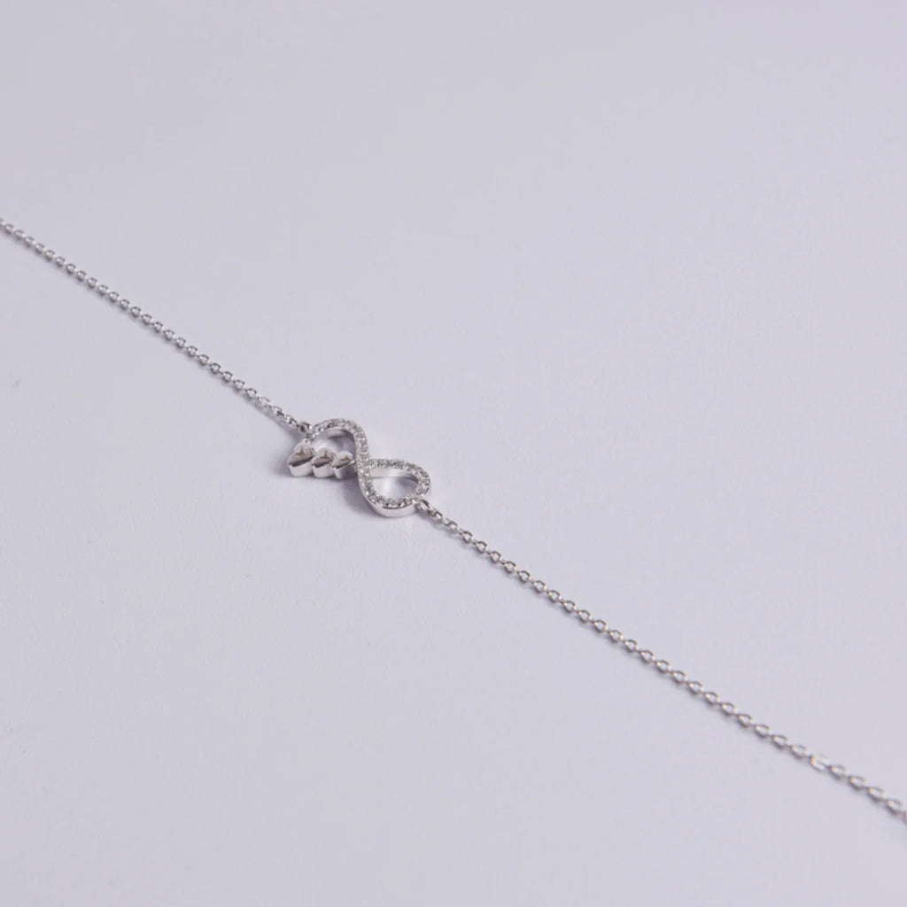Cadena de mano plata de ley diseño infinito, detalle tres corazones y cierre ajustable con colgante final, joyería hipoalergénica.