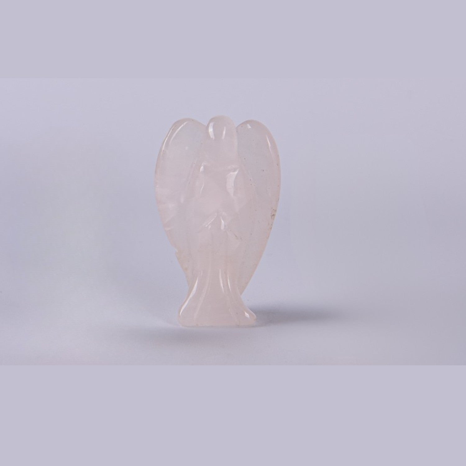Figura de Ángel de la Guarda en mineral Cuarzo Rosa pulido sobre fondo blanco. Tono rosado suave y acabado brillante.