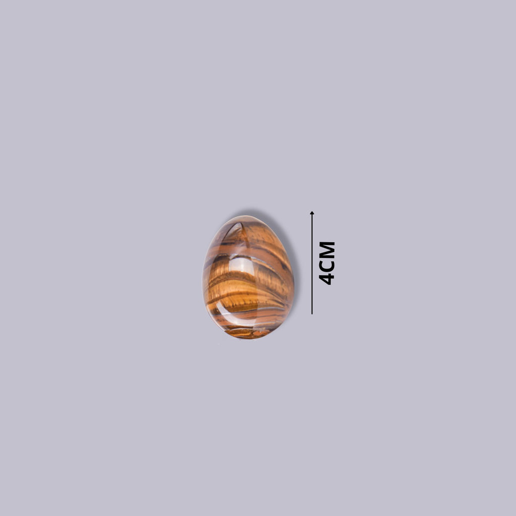 Guía de tamaño del huevo de piedra Ojo de Tigre indicando 4 cm de altura. Mineral de color pardo y dorado pulido.