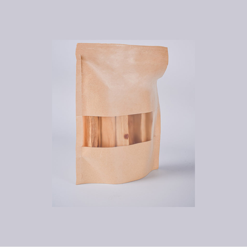 Bolsa de 80g de Palo Santo de Perú Premium en packaging sostenible de papel kraft con ventana transparente. Incienso natural para el hogar.