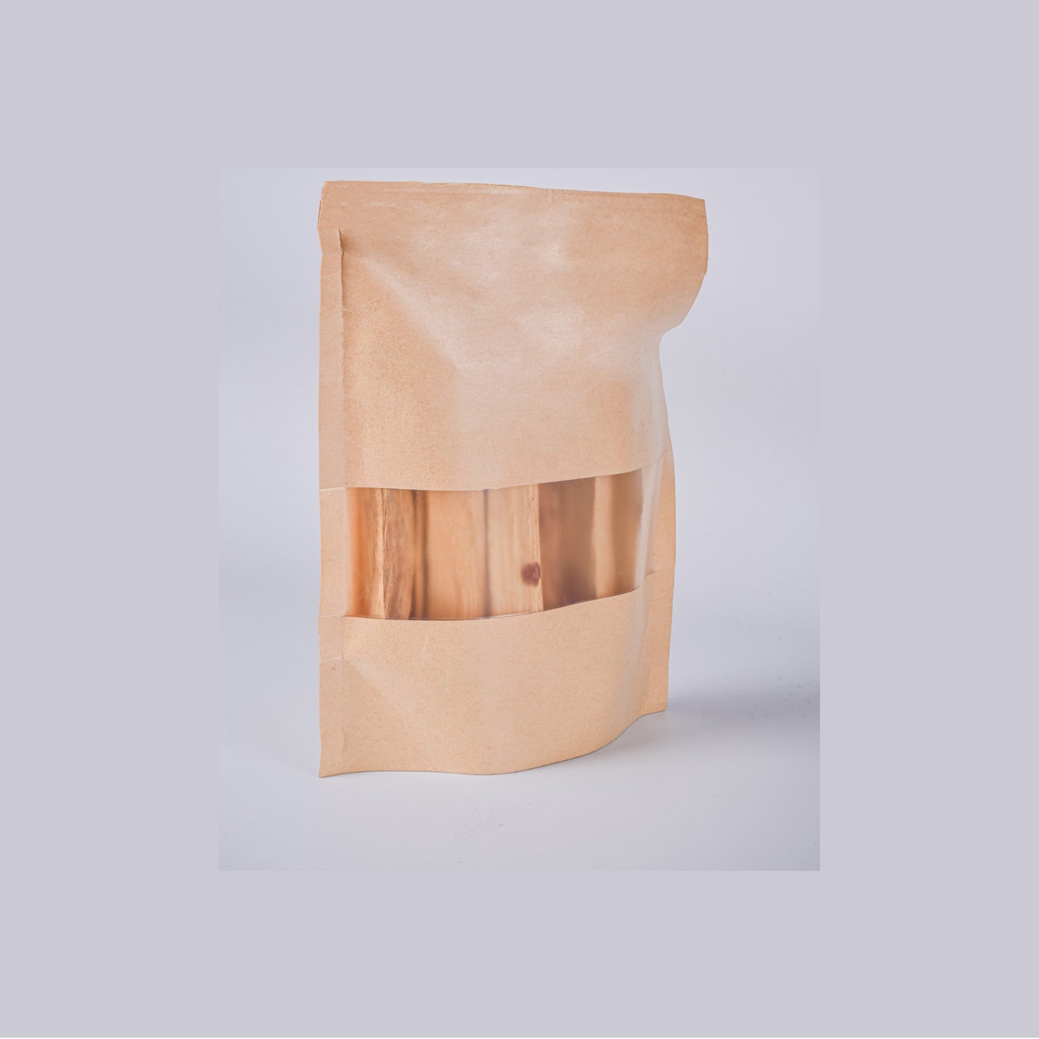 Bolsa de 80g de Palo Santo de Perú Premium en packaging sostenible de papel kraft con ventana transparente. Incienso natural para el hogar.