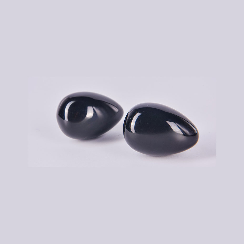 Pareja de huevos de Obsidiana Negra mostrando su superficie lisa, brillante y reflectante como un espejo negro.