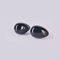 Pareja de huevos de Obsidiana Negra mostrando su superficie lisa, brillante y reflectante como un espejo negro.