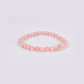 Pulsera elástica de bolas redondas de Piedra Sol natural sobre fondo blanco. Detalle del color naranja melocotón y las inclusiones brillantes típicas del mineral.