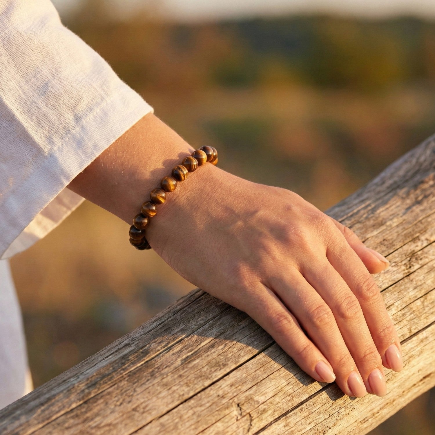 Pulsera de cuentas de Ojo de Tigre natural brillando al sol en la muñeca. Joyería energética para potenciar la fuerza de voluntad, la seguridad y la protección personal.