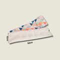 Cojín térmico lumbar y cervical de semillas. Modelo largo con estampado moderno de triángulos naranjas y azules, funda extraíble 100% algodón.