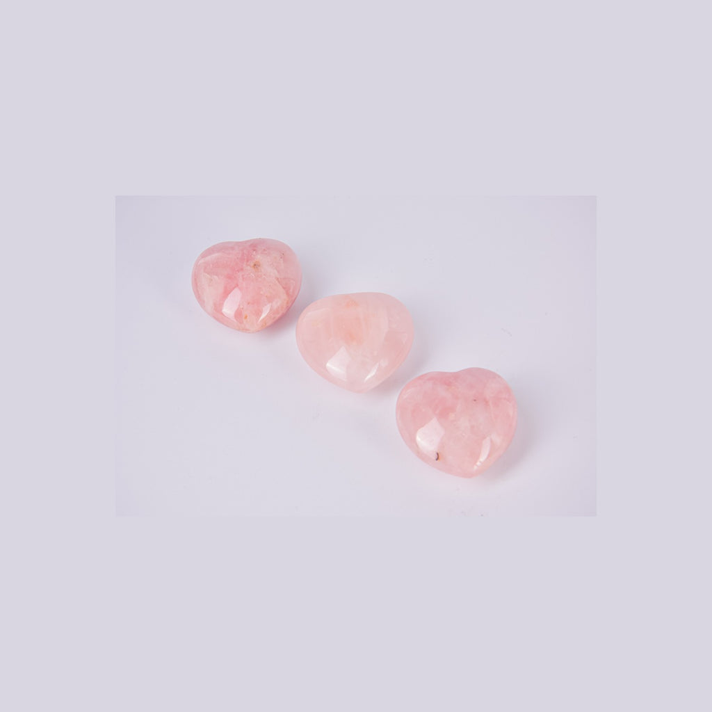 Muestra de tres corazones de Cuarzo Rosa para apreciar la variedad de tonos naturales y vetas únicas de cada pieza. Tamaño de referencia 4cm.