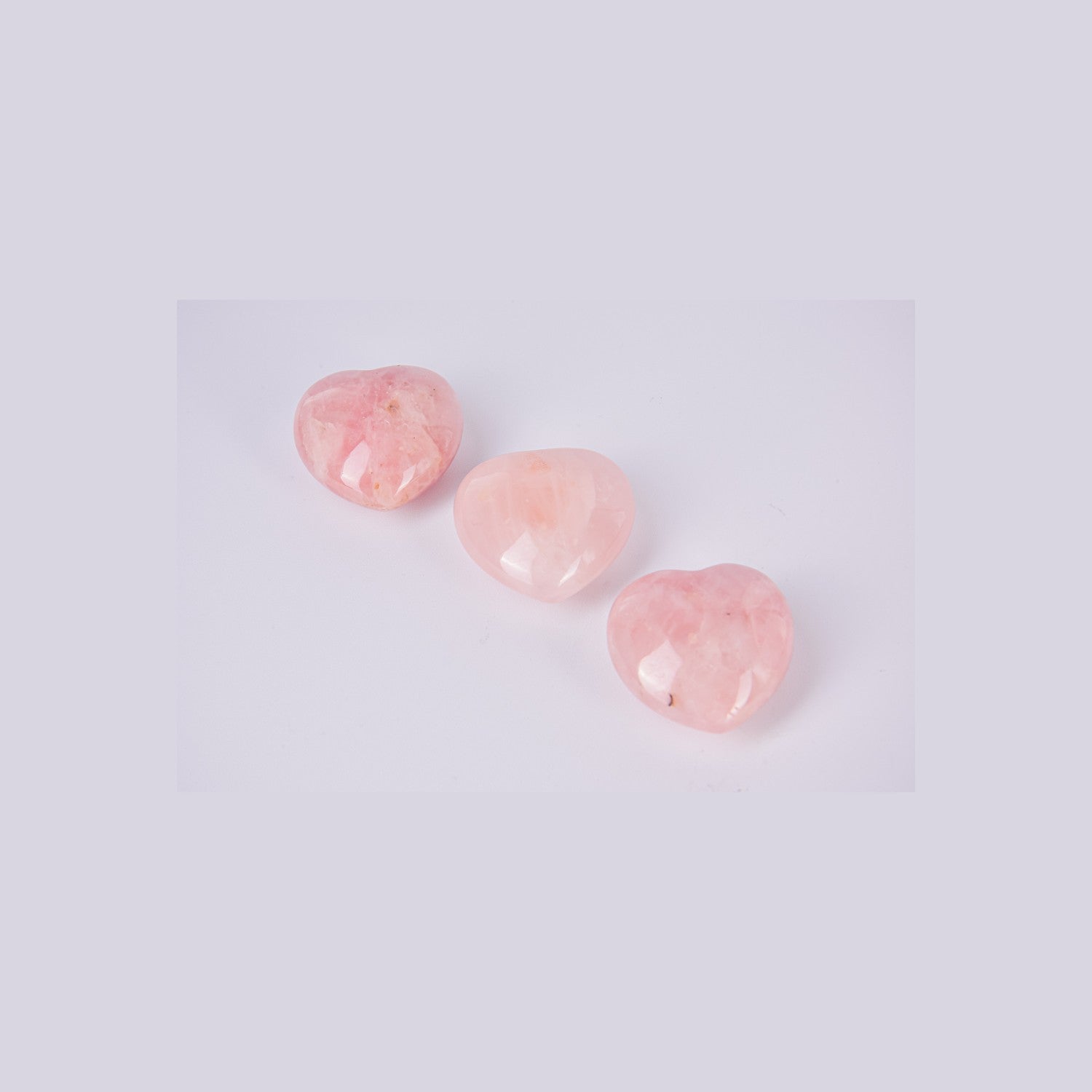 Muestra de tres corazones de Cuarzo Rosa para apreciar la variedad de tonos naturales y vetas únicas de cada pieza. Tamaño de referencia 4cm.
